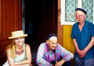 Kathryn sitting on porch with man who has been blinded and his nephew, Belarus.